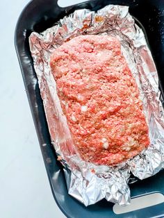 the meatloaf is covered in tin foil and ready to be cooked on the grill