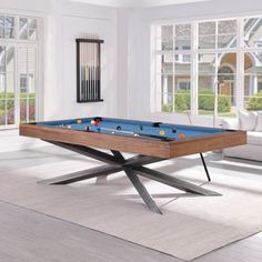 a pool table in the middle of a living room with white walls and flooring