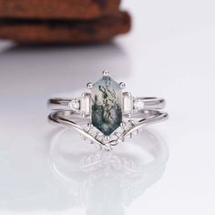 Need a new ring design to add to your collection? Few can offer quite the same magical and exquisite appeal as our gorgeous Desi moss agate ring. Each Desi ring is made with care, featuring a stunning 1.0-carat center stone and finished with countless reflective, beautiful CZ crystals for a magical look overall. ✦ DETAILS ✦✧ Handcrafted ✧ 0.75 Carat center stone✧ Moss Agate and crystals ✧ Sizes 3.75-14.25 Moss Agate Jewelry, Timeless Ring, Green Moss Agate, Moss Agate Ring, Leaf Ring, Agate Jewelry, Agate Ring, Richmond Va, Anniversary Gift For Her