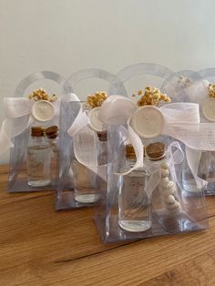 four clear bottles filled with different types of candies on top of a wooden table