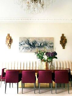 a dining room table with red chairs and a chandelier