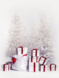 a pile of wrapped presents sitting in front of a christmas tree