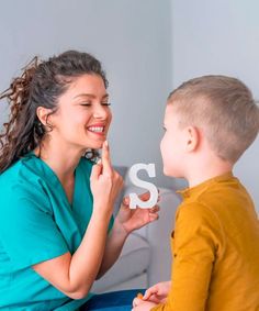 a young boy and woman sitting next to each other with the letter s in front of them