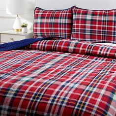 a bed with red and blue plaid sheets