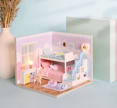 a doll house with furniture and accessories on the floor next to a vase filled with flowers