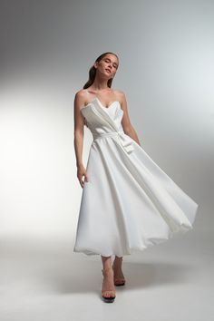 a woman in a white dress posing for the camera