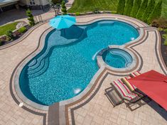 an aerial view of a swimming pool with lounge chairs and umbrellas