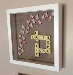 a scrabble frame with words and butterflies in the shape of letters that spell out faith