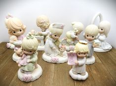 a group of little figurines sitting on top of a wooden table next to each other