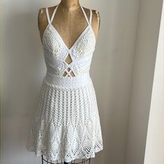 a white crochet dress is on a mannequin with an open back