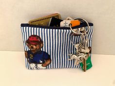 a blue and white striped purse with a bear keychain