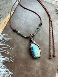 Embrace the mystical energy of labradorite with this handmade pendant in antiqued copper. This bohemian necklace features a macrame detail for a unique touch. Perfect for those who love artisan jewelry. This pendant is wire wrapped and hand woven in solid copper with a labradorite Cabochon and then oxidized and hand polished to give that antiqued look. ★★material and size★★ Pendant size approx : 56x23 mm (labradorite approx  :  33x19mm) Polyester cord with macrame decoration , wood bead , brass bead, coconut shell beads Necklace max length approx : 74  cm (adjustable with slide lock) ★★packaging★★ packing with paper box and bubble paper to assure safety. ★★shipping★★ Items will be shipped within 1-3 business days after the payment has cleared.   Purchases are sent by local Registered Mail Macrame Decoration, Shell Beads Necklace, Macrame Pendant, Gemstone Beads Jewelry, Labradorite Cabochon, Boho Pendant, Bohemian Necklace, Labradorite Pendant, Shell Beads