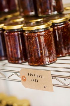 several jars of pickle and ball cherry jam on a rack with a price tag