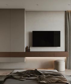 a large flat screen tv mounted to the side of a wall next to a bed