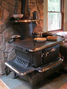 an old fashioned stove in a stone walled room