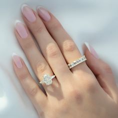 a woman's hand with two engagement rings on her left and the other hand holding an engagement ring