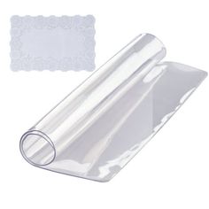 a roll of clear plastic wrapping paper next to a white doily on a white background