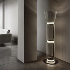 a tall glass vase sitting in the middle of a room