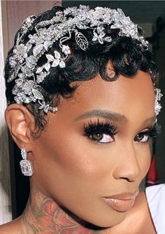 a woman with tattoos on her neck and head wearing a tiara, earrings and makeup