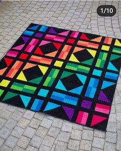 a multicolored area rug is shown on the ground with bricks in front of it