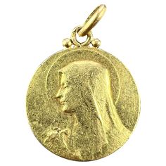 A French 18 karat (18K) yellow gold charm pendant designed as a medal representing the Virgin Mary with a lily to one side, and the holy dove to the other, engraved with a monogram RB/BR and the date 5 Aout 1926. Signed Becker, stamped with the eagle's head for French manufacture and 18 karat gold with an unknown maker’s mark. Dimensions: 2.1 x 1.8 x 0.13 cm (not including jump ring) Weight: 3.34 grams (Chain not included) Vintage Pendant Necklace, The Virgin Mary, Yellow Gold Pendants, Maker's Mark, Pendant Design, Gold Charm, Virgin Mary, Vintage Necklace, Gold Pendant