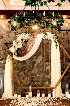 a wedding arch with flowers and candles