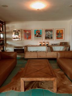 a living room filled with furniture and pictures on the wall