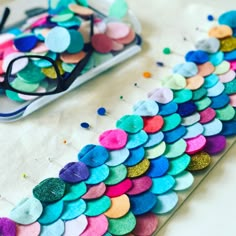 a pair of glasses sitting on top of a table covered in colorful confetti