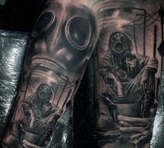 a man's arm with tattoos on it and two people wearing gas masks in the background