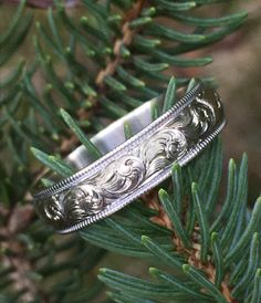 a silver ring sitting on top of a tree branch