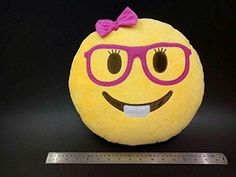 a yellow smiley face with glasses and a pink bow on it's head, sitting next to a ruler