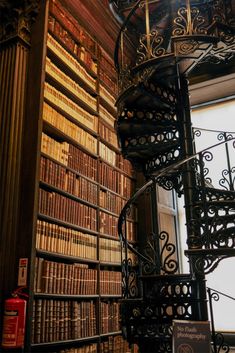 a spiral staircase in front of a bookshelf