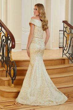 a woman in a white dress standing on some stairs