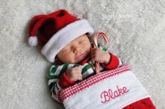 a baby wearing a santa hat and holding a candy cane