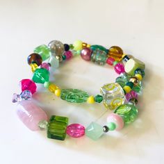 I made these with a mix   of new and vintage beads in shades of pinks, greens, yellow and more, made with glass, metal and other materials! Wear them together, alone or with other bracelet friends!  ☀️Elastic/Stretchy☀️ One size fits most.  Thank you so very much for visiting my shop!! Click here for more: http://www.etsy.com/shop/jHenSunshine New to my shop? See my policies section for any additional questions. Colorful Bohemian Beaded Bracelets For Party, Spiritual Green Czech Glass Beads, Green Czech Glass Spiritual Beads, Spiritual Green Beaded Bracelets With Colorful Beads, Colorful Bohemian Faceted Beads, Unique Multicolor Faceted Beads, Colorful Faceted Beaded Bracelets, Multicolor Beaded Glass Bracelets, Green Spiritual Bead Bracelet