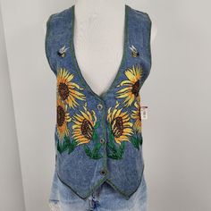 Agapo A Charming Vintage Denim Vest Adorned With Vibrant Sunflower And Bee Embroidery. A Piece That Brings A Touch Of Nostalgia And Whimsy To Any Wardrobe. 90's Teacher Vibes Button Closure Embroidered Sunflowers & Bees 100% Cotton Measurements: Chest Width 19 Inches Length 24 Inches Vintage Deadstock New With Tags. Please See Description, Measurements And Picture(S) For Additional Item Specifics ***Offers Welcomed ***Bundle And Save Casual Embroidered Denim Vest For Spring, Summer Cotton Denim Vest With Floral Embroidery, Casual Embroidered Denim Vest For Summer, Spring Blue Denim Vest, Embroidered Blue Denim Vest For Summer, Summer Embroidered Blue Denim Vest, Casual Denim Vest With Floral Embroidery For Spring, Fitted Embroidered Denim Vest Casual, Casual Embroidered Fitted Denim Vest