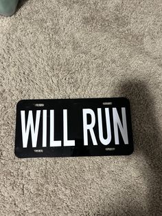 a license plate that says will run on the floor next to a pair of shoes