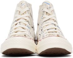 High-top canvas sneakers in off-white featuring splatter effect in blue, black, and white. Round rubber cap toe. Lace-up closure in white. Eyelet vents and leather logo patch in white at inner side. Tonal webbing trim at heel. Rubberized stripe in red at welt. Tonal rubber midsole featuring rubberized stripe and logo patch in black and blue at heel. Treaded rubber outsole in brown. Silver-tone hardware. Supplier color Egret/Digital blue/Egret Converse Beige, Converse Off White, Converse For Women, High Sneakers, Chuck 70, White Eyelet, Brown Silver, Leather Logo, Paint Splatter