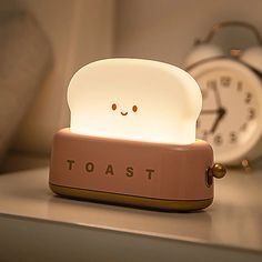 a toaster shaped lamp sitting on top of a table next to an alarm clock