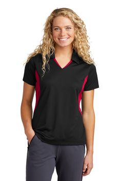 a woman wearing a black and red shirt with long blonde hair smiling at the camera