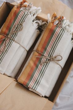 two wrapped gift bags sitting in a box