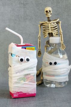 a skeleton next to a bottle with a toothbrush in it and a tube wrapped around it