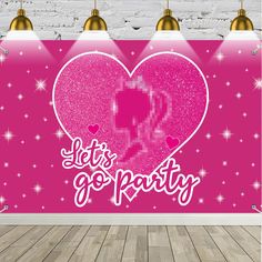 an image of a pink party backdrop with hearts and sparkles on the floor in front of a brick wall that says let's go party