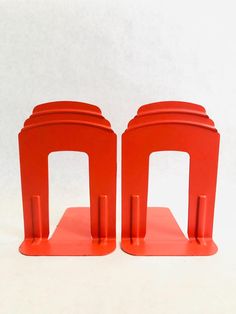 two red bookends sitting on top of each other in front of a white background