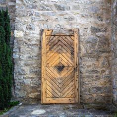 an old wooden door sitting in front of a stone wall