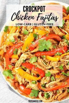 crockpot chicken fajitas in a white bowl with cilantro and red peppers