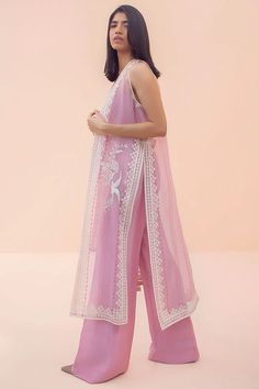 This powder pink sleeveless organza cape with block print is the perfect embodiment of modern chic. The piece has an embroidered bird motif that adds to its simplistic appeal. The cape is paired with a matching choli with a diamante embellished strap and matching raw silk bootleg trousers. Kurti With Piping Design, Unique Indian Wear, Modern Indian Outfits Casual, Modern Indian Fashion, Fashion Outfits Indian, Organza Salwar, Organza Cape, Sania Maskatiya, Casual Indian Fashion