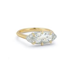 an oval diamond ring with three small diamonds on the band, set in yellow gold