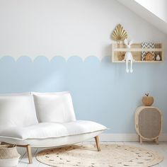 a white couch sitting on top of a wooden floor next to a shelf filled with vases