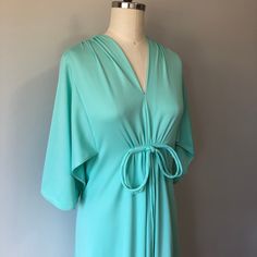 "A lovely comfortable style vintage dress in perfect condition! Hidden zipper down the back and a bow detail in the front. The Sleeves have a beautiful flowy elegant style to them. Size: S/M Tag - none Era - 60s Material - polyester, nylon zipper, metal hook and eye Bust - 32 to 34\" Waist - 26 to 28\" Hips - 35 to 37\" comfortably Length - 44\" Washing - cold delicate cycle in laundry bag or hand wash/lightly steam clean" Retro V-neck Wedding Dress, 60s Fashion Dresses, Teal Green Dress, Vintage Green Dress, Style Année 60, Vintage 60s Dress, Silver Evening Dress, Vintage Dress 60s, Vintage Black Dress